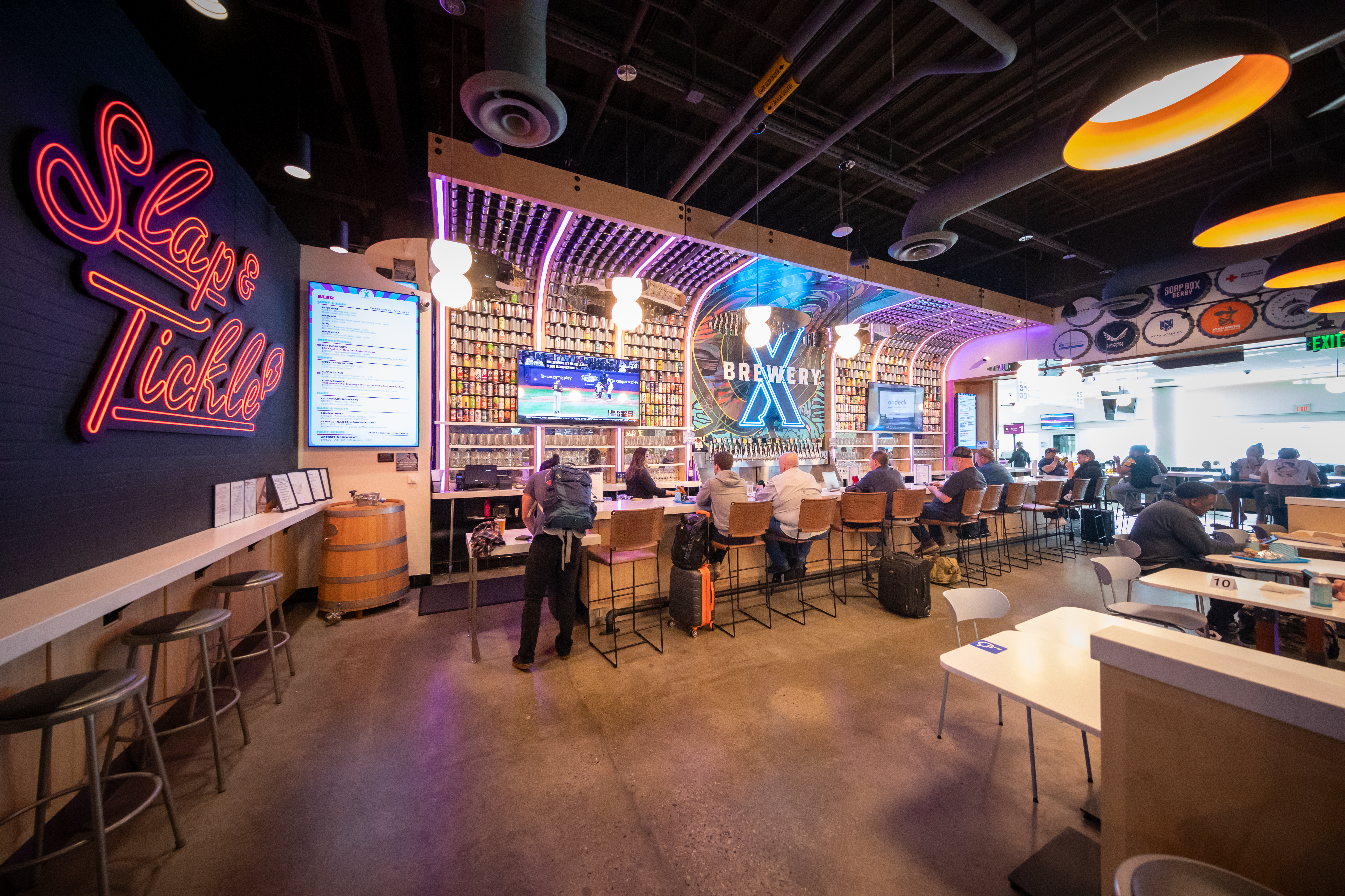 Colorful restaurant interior with neon signs and lively dining atmosphere.
