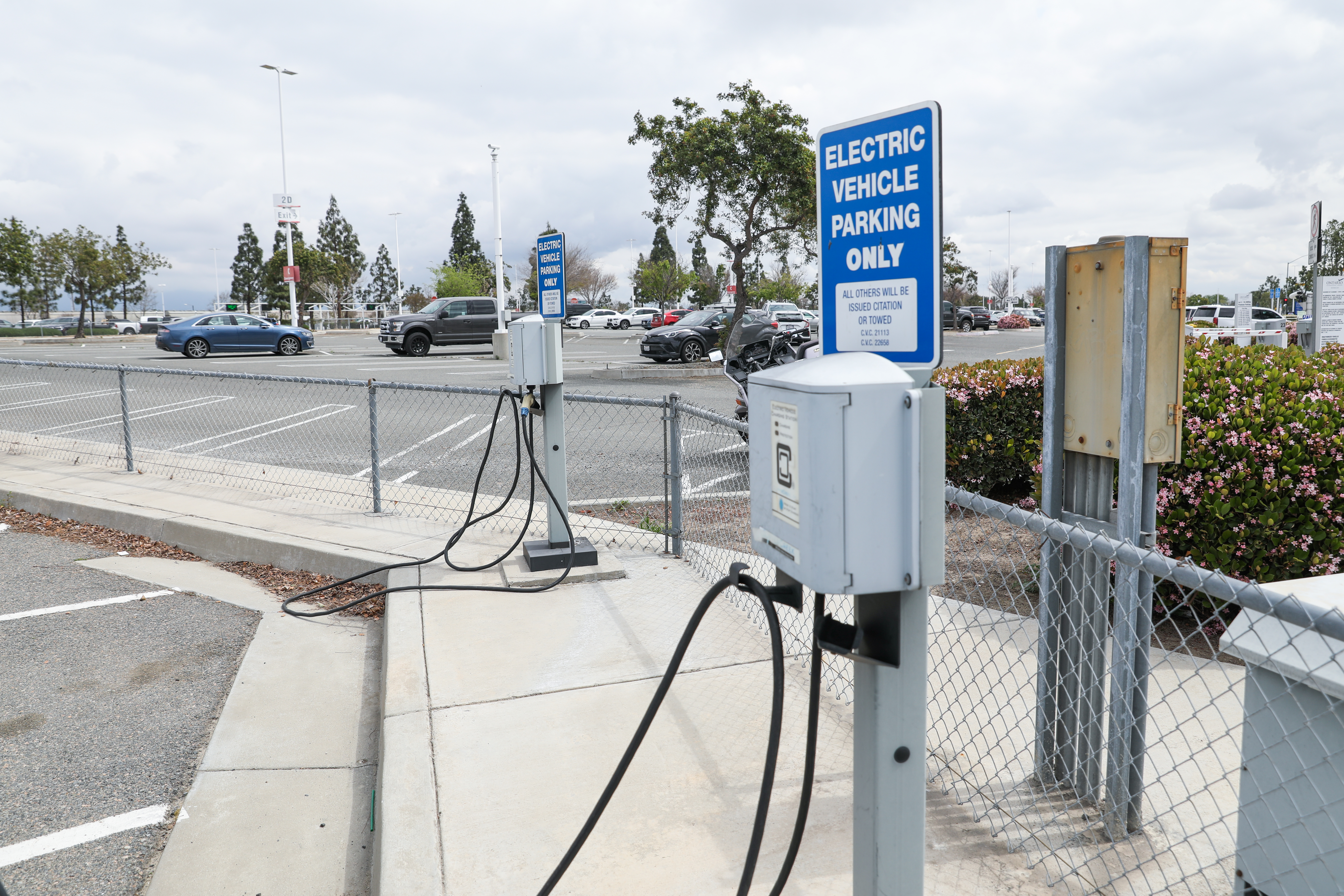 Two EV charging stations are shown in an ONT parking lot with signs that read "Electric vehicle charging only."