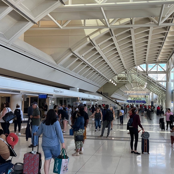 Crowded airport terminal with people walking with their luggages