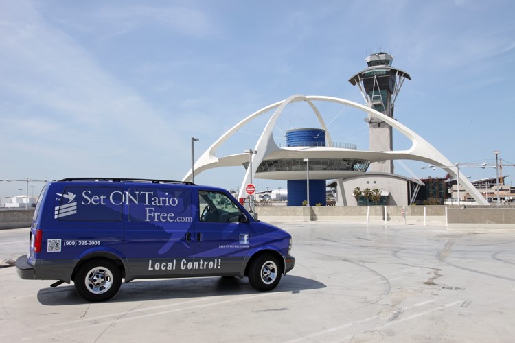 A blue van with the Set ONTario Free logo is parked in front of LAX.