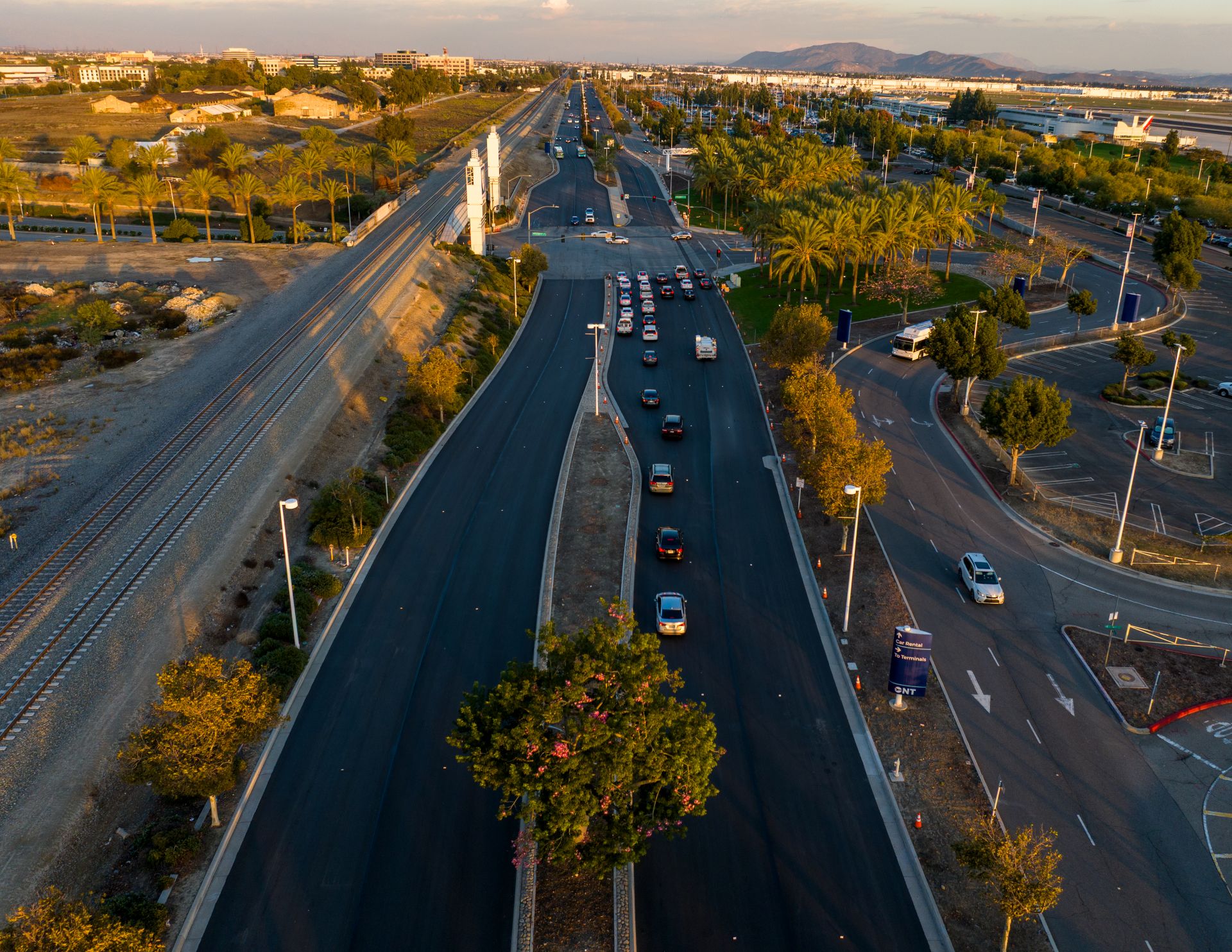 An aerial shot shows Airport Drive recently repaved with cars driving on it.