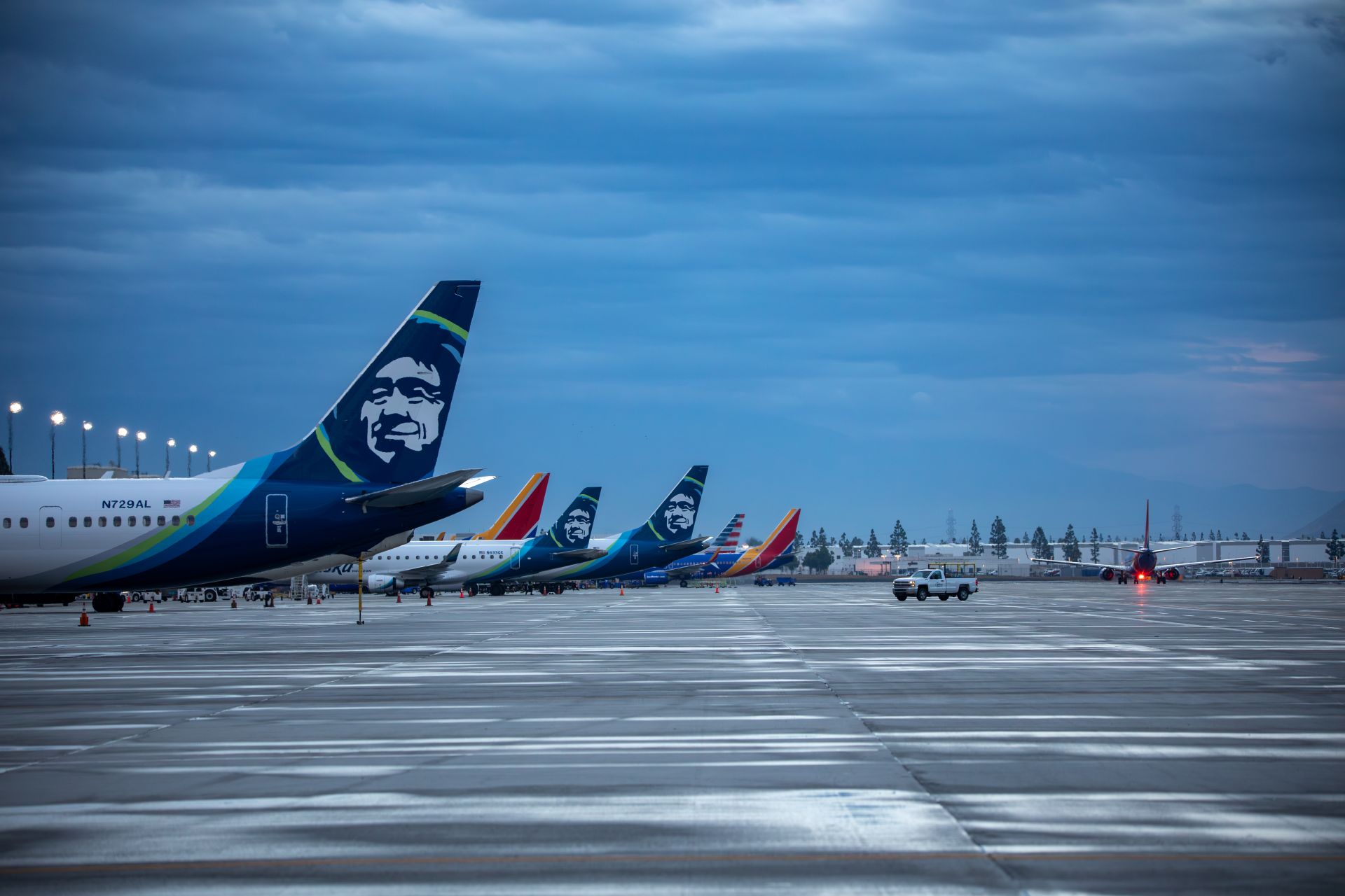 Tales of planes are seen sitting on the runway at ONT in the early morning light of a cloudy day.