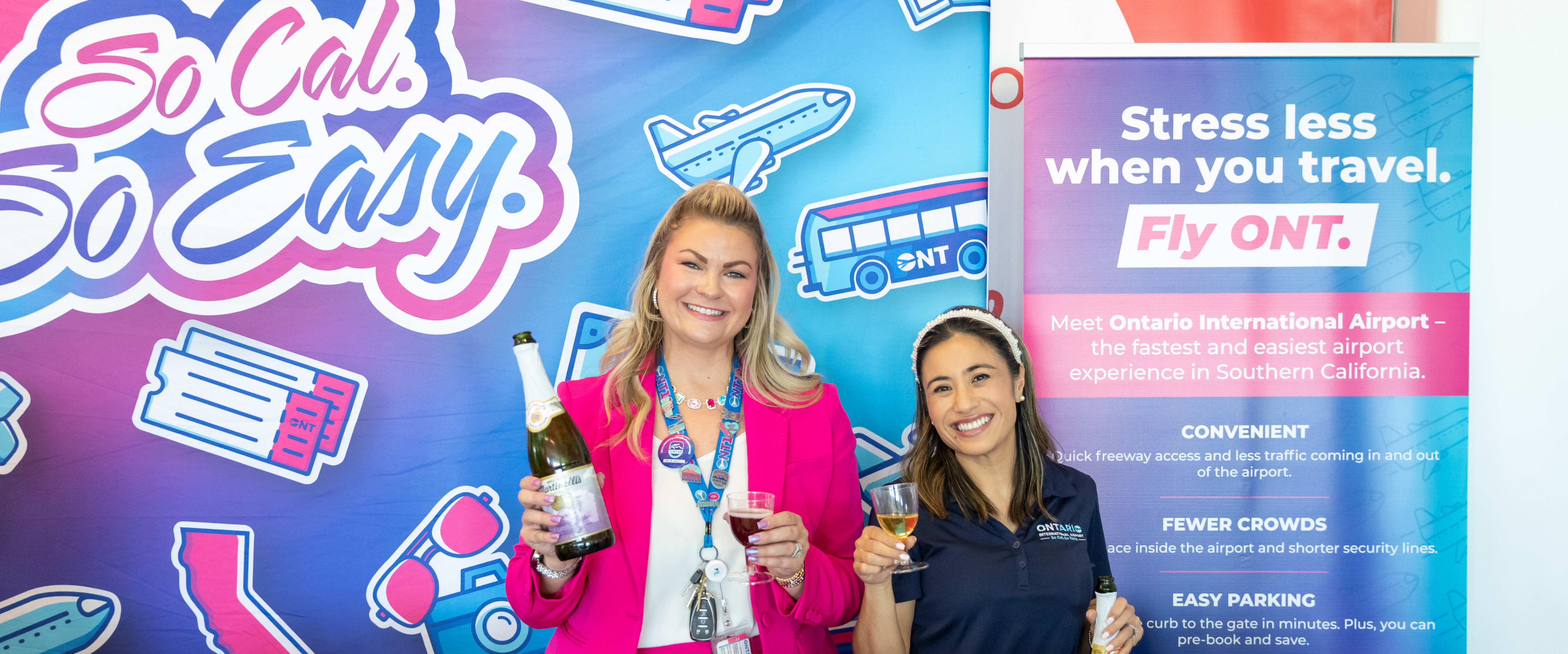 A vibrant image showing a smiling woman standing in front of a colorful backdrop with the text "Be Our Guest" and other promotional information.