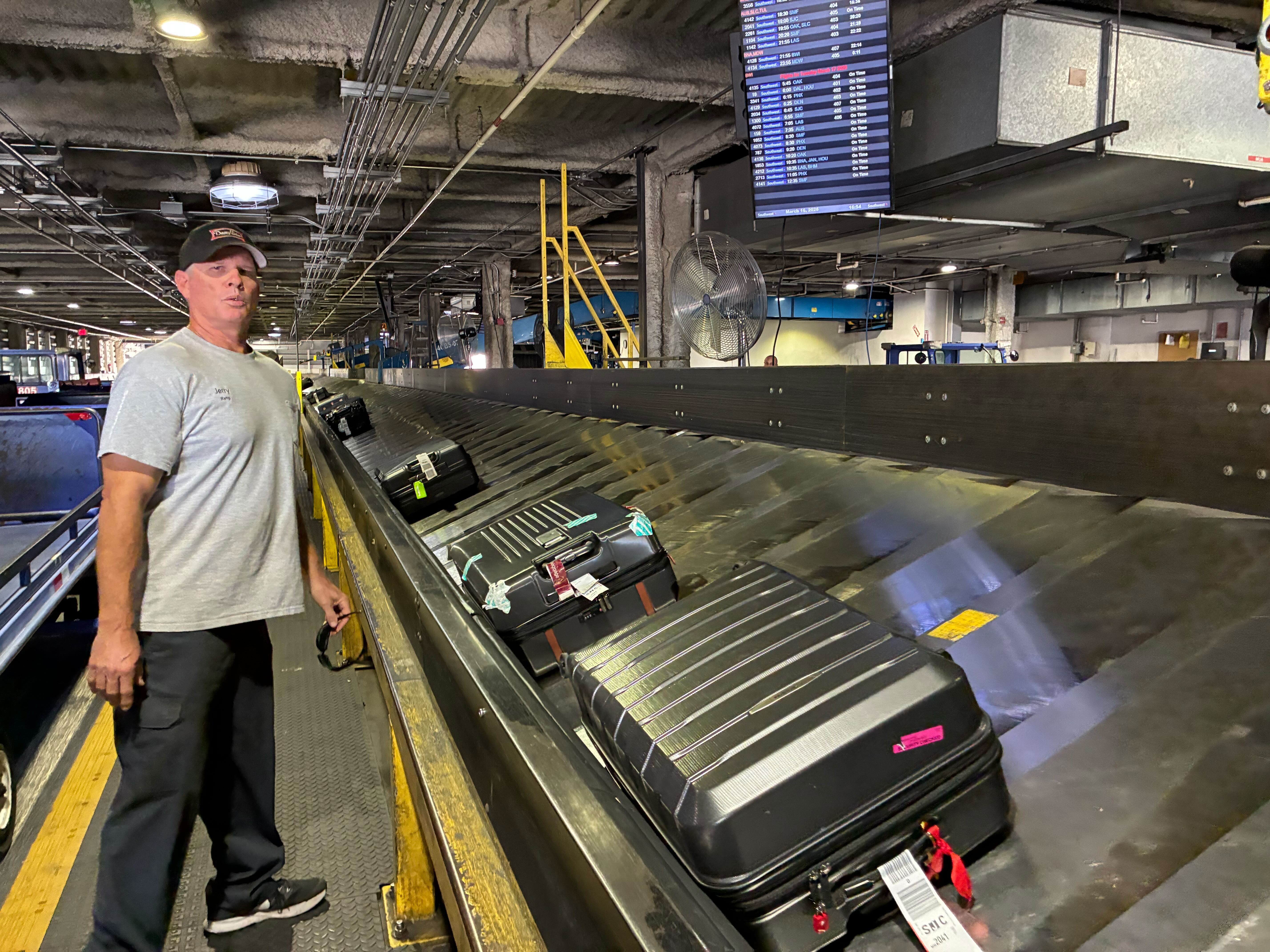 Jerry Griffin next to baggage Conveyor Baggage Handling Belt System.