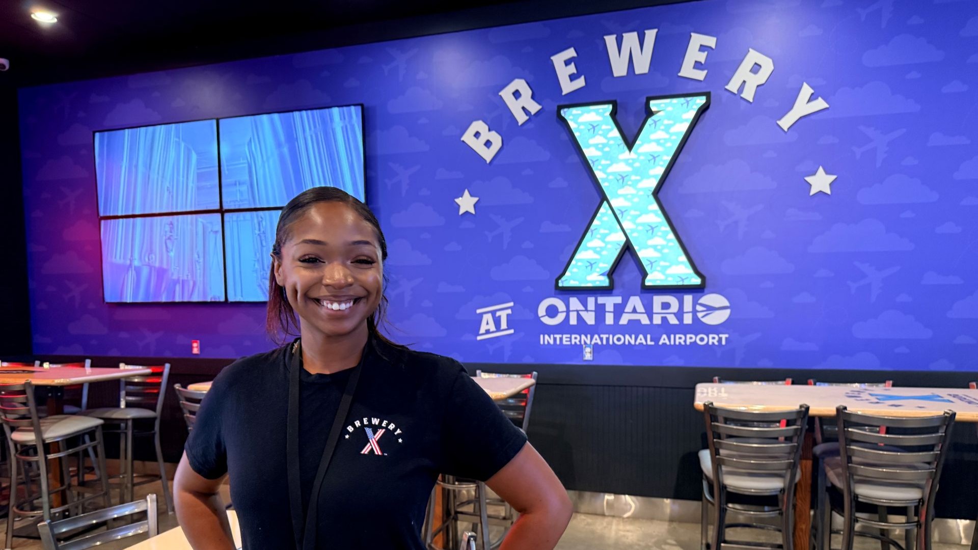 Aarynn brewery x lead stands in front of brewery x logo at ONT