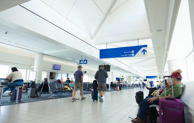 Passengers seated near a gate 404 with their luggage. 