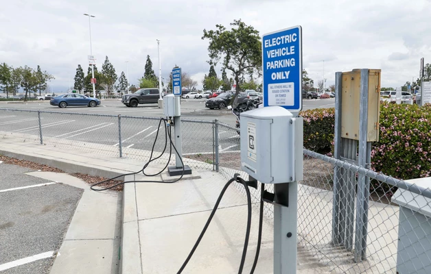 Electric vehicle parking sign and charging station in the airport parking lot.