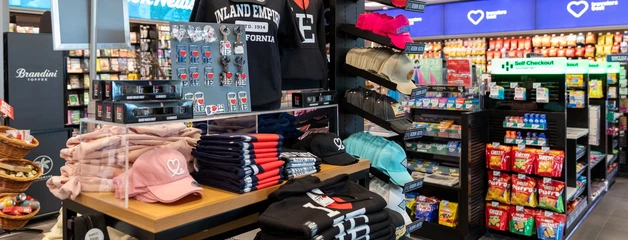 Inside a Hudson store at ONT, shelves show black T-shirts and hats that say 1LoveIE.