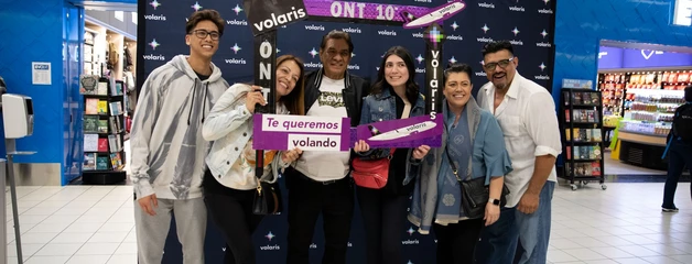 Six people pose with photo props promoting the Volaris being at ONT for 10 years.