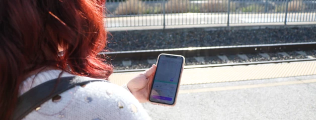 A woman uses a phone to look for a ride-share car.
