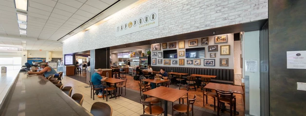 The Tap & Pour restaurant is shown with a few people sitting in seats.