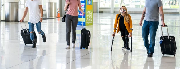 Four people walking down the way near baggage claim in the terminal 
