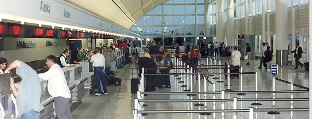 Passengers stand at ticket counters for Alaska Airlines in the one of the recently opened twin terminals.