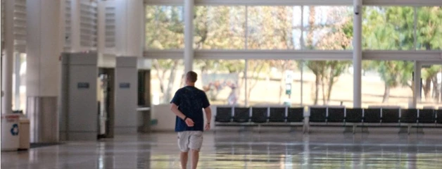 One man walks through an otherwise empty baggage claim area.