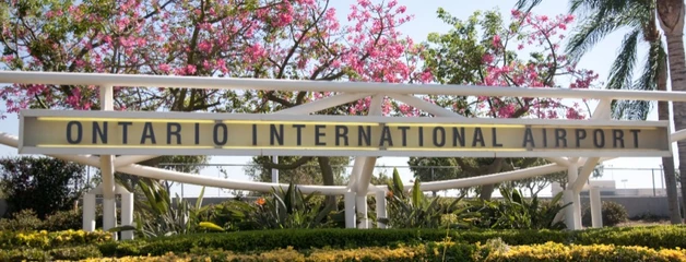 A sign reads "Ontario International Airport" with landscaping around it.