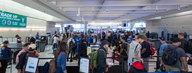 Busy terminal with winding line of passengers entering security checkpoint