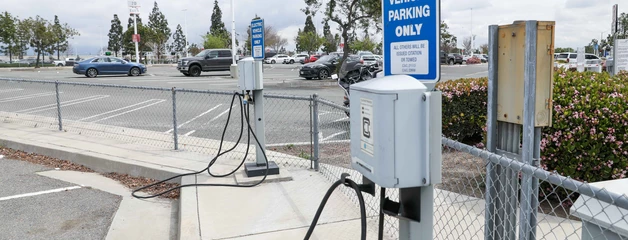 Electric vehicle parking sign and charging station in the airport parking lot.