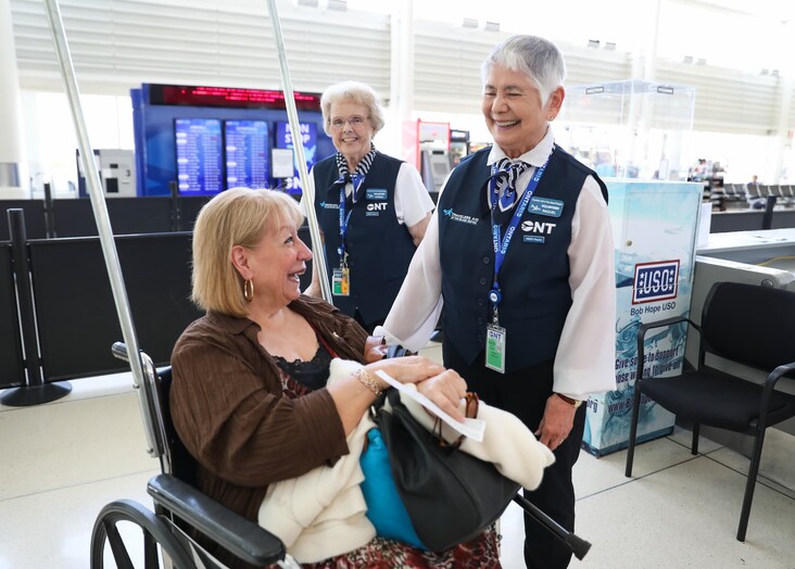 Airport security personnel checking a passenger's documents at a terminal.